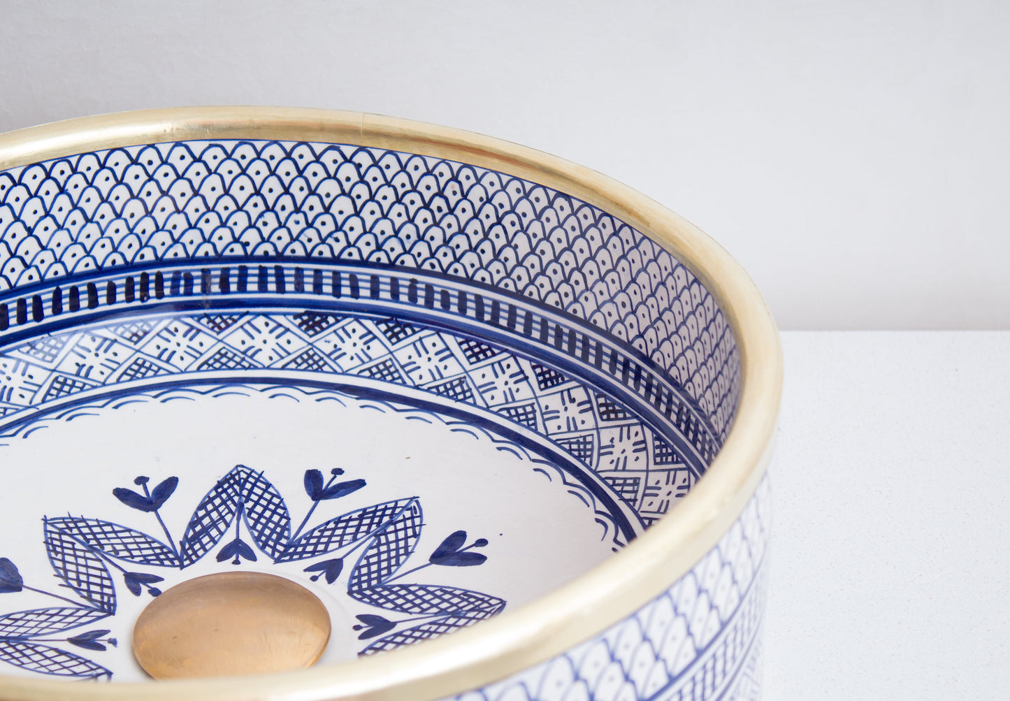 Angled interior view of Moroccan ceramic sink showcasing blue geometric border patterns and central floral motif design