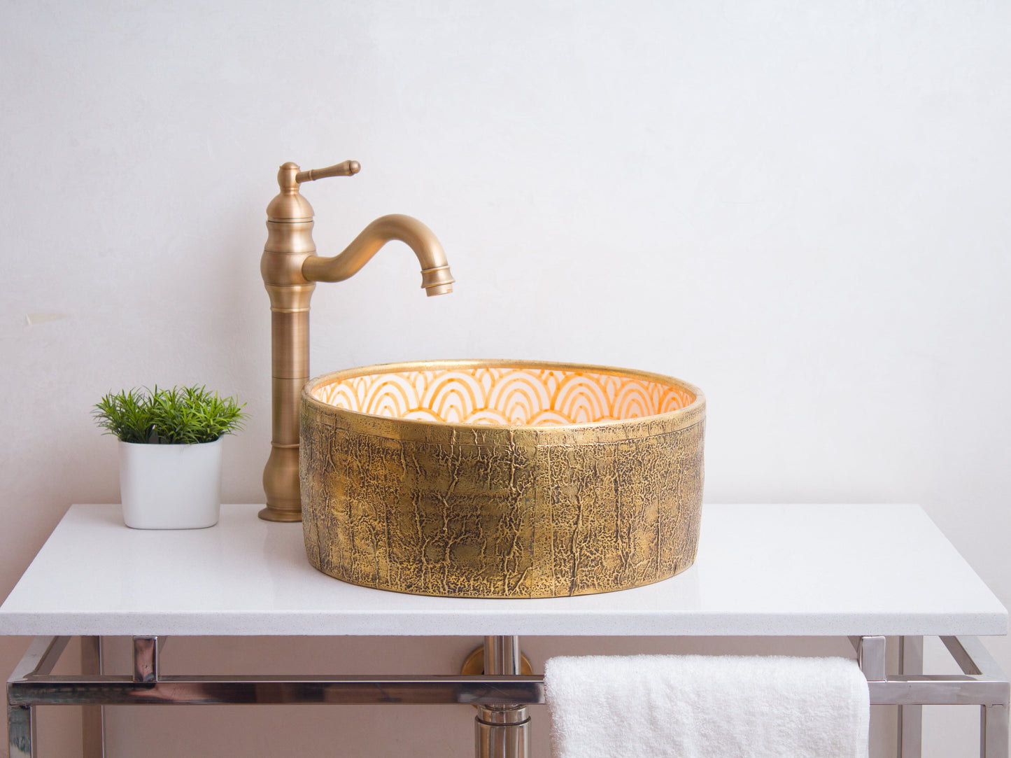 Artisan ceramic vessel sink positioned on contemporary bathroom counter with traditional brass faucet and modern styling