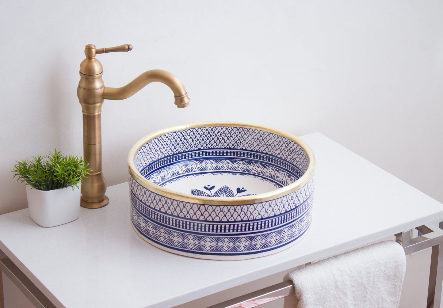 Handmade ceramic vessel sink positioned on contemporary bathroom counter with brass faucet in modern bathroom setting