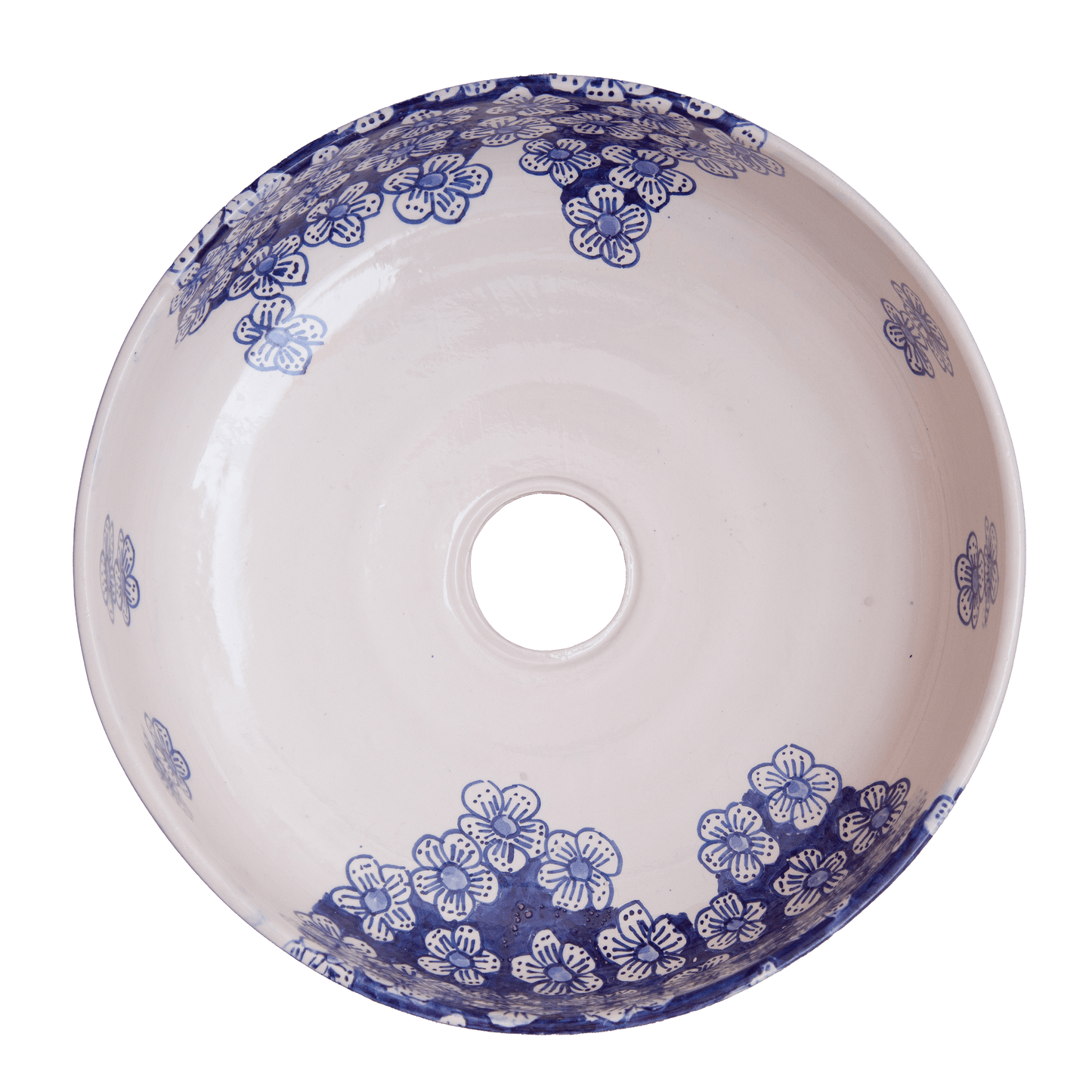 Top-down interior view of ceramic vessel sink displaying scattered blue floral motifs and clustered flower patterns with central drain opening