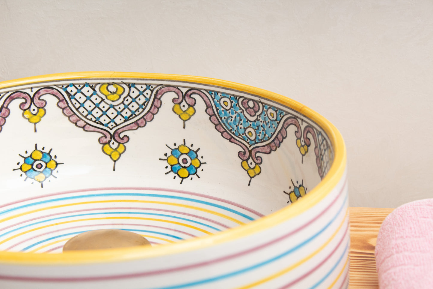 Moroccan ceramic sink rim detail displaying hand-painted geometric patterns and decorative motifs