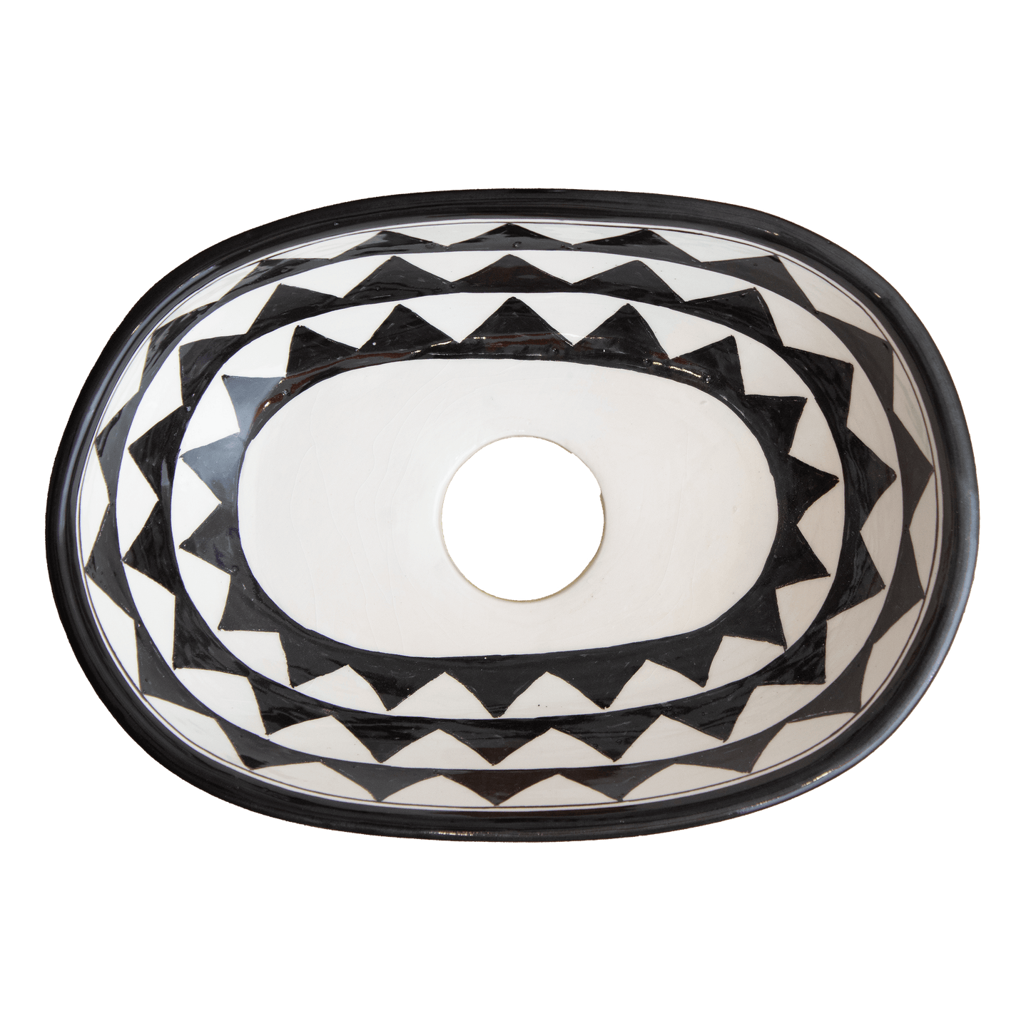 Top-down interior view of small oval ceramic vessel sink showing concentric geometric triangle patterns and central drain opening