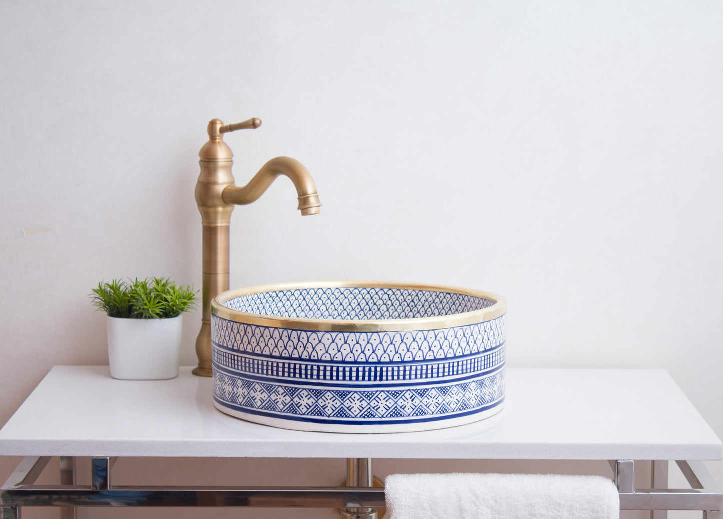 Side profile view of round ceramic vessel sink showing blue geometric pattern bands and bathroom installation