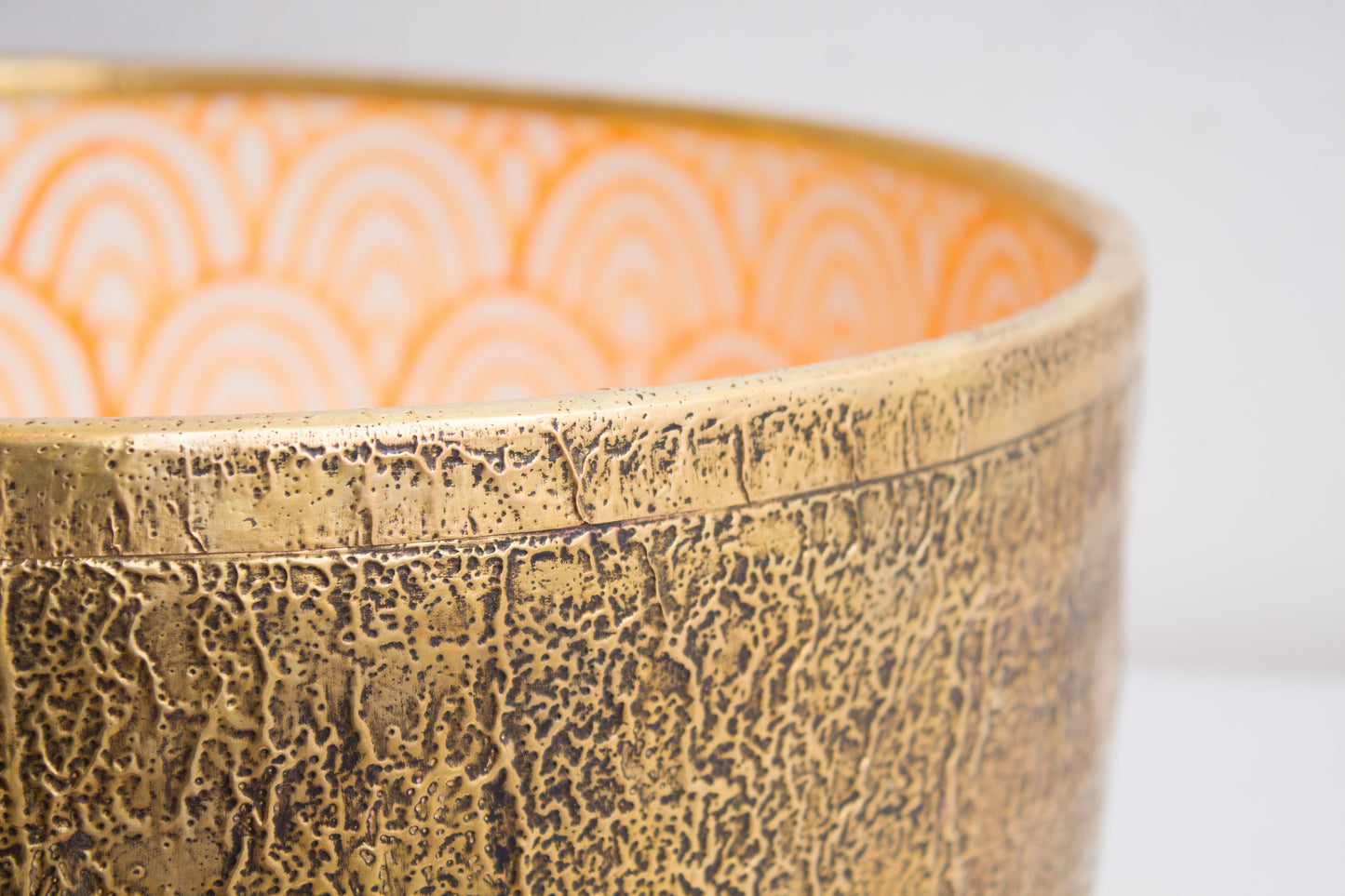 Macro detail view of handcrafted ceramic basin rim showcasing crackled brass textured exterior finish and craftsmanship
