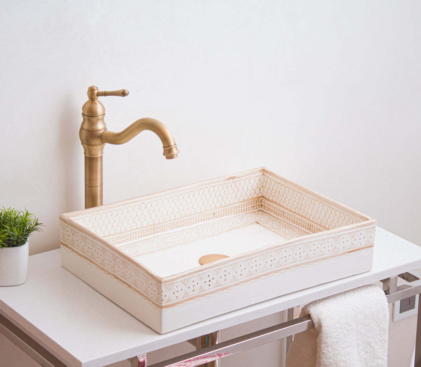 Handcrafted rectangular sink photographed from side angle showcasing detailed beige border patterns