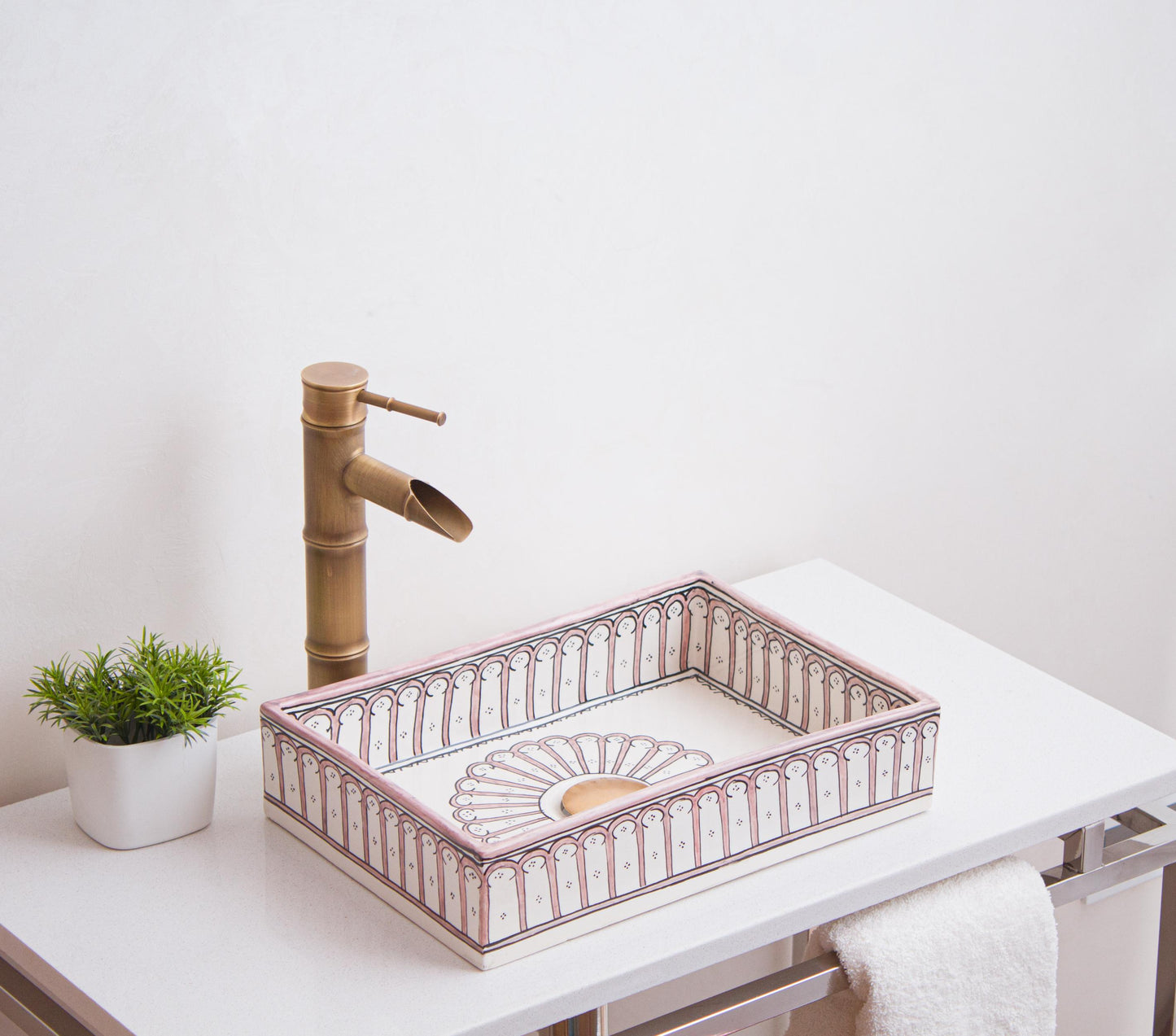 Artisanal ceramic vessel sink featuring interior sunburst medallion and arch border patterns positioned on modern bathroom vanity with brass fixtures