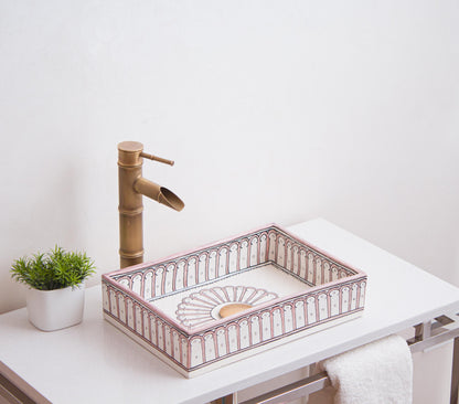 Artisanal ceramic vessel sink featuring interior sunburst medallion and arch border patterns positioned on modern bathroom vanity with brass fixtures