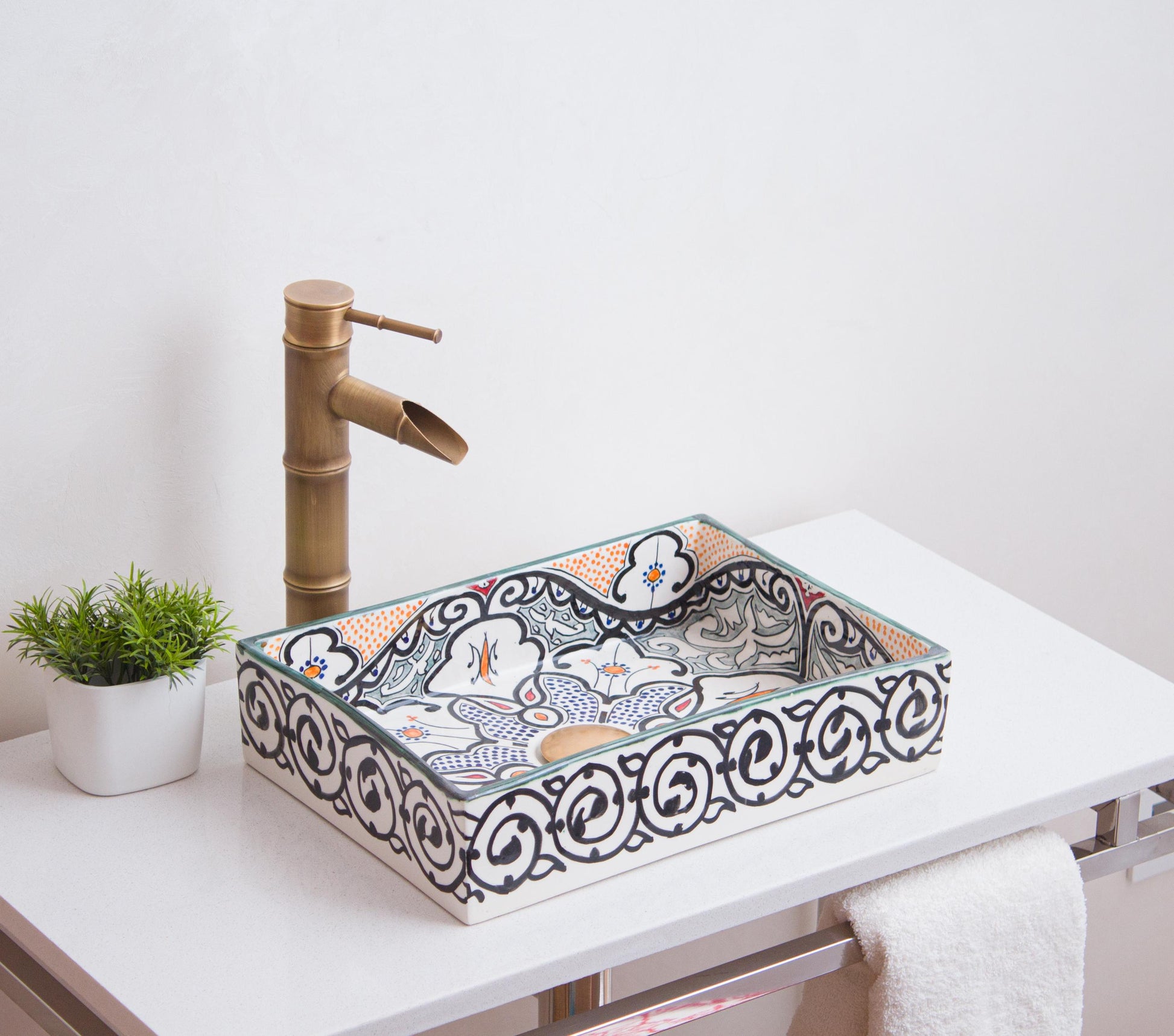 Artisanal ceramic vessel sink featuring intricate geometric patterns and orange accents positioned on modern bathroom vanity with brass fixtures
