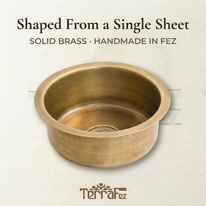Round solid brass bar sink shaped from a single sheet, handmade in Fez, Morocco by TerraFez, showing aged patina finish and seamless construction