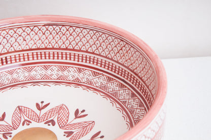 Angled interior view of Moroccan ceramic sink showcasing coral pink geometric border patterns and central floral motif design