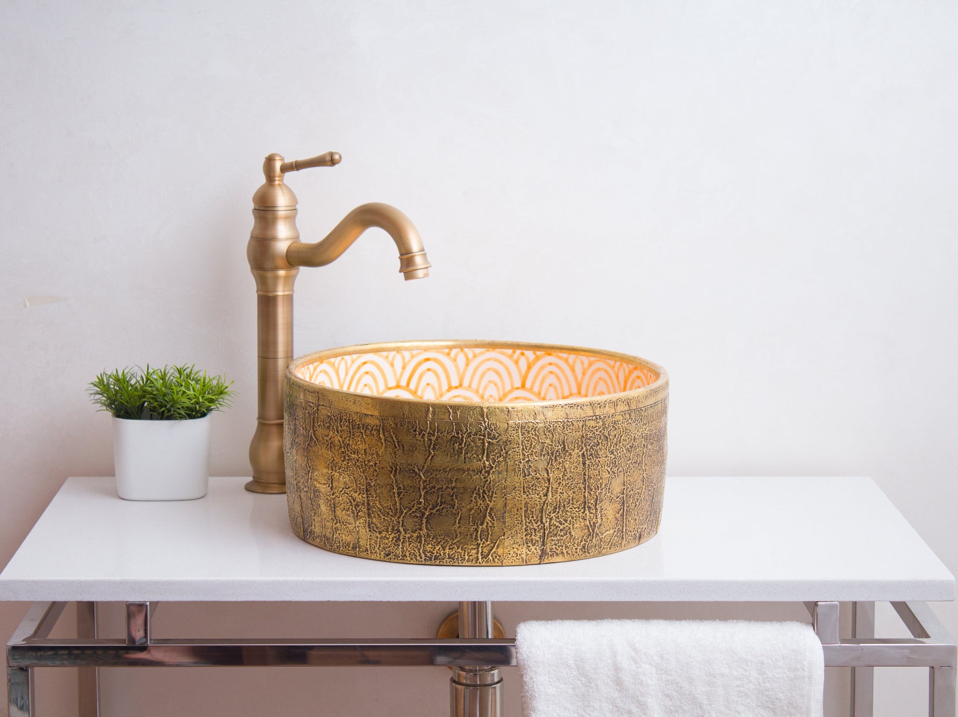 Artisan ceramic vessel sink positioned on contemporary bathroom counter with traditional brass faucet and modern styling