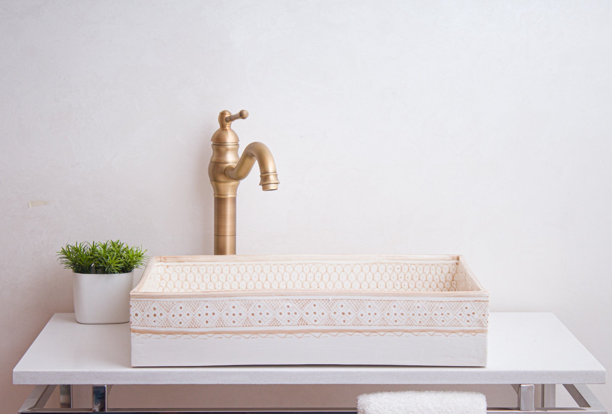 Front lifestyle view of beige vessel sink with brass faucet in contemporary bathroom setting