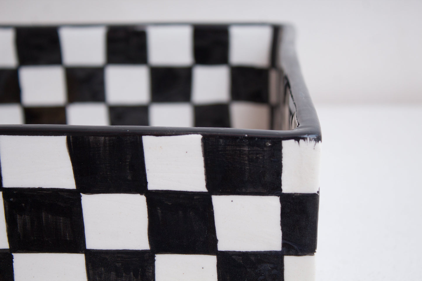 Close-up detail of black and white checkered pattern on rectangular basin rim and exterior
