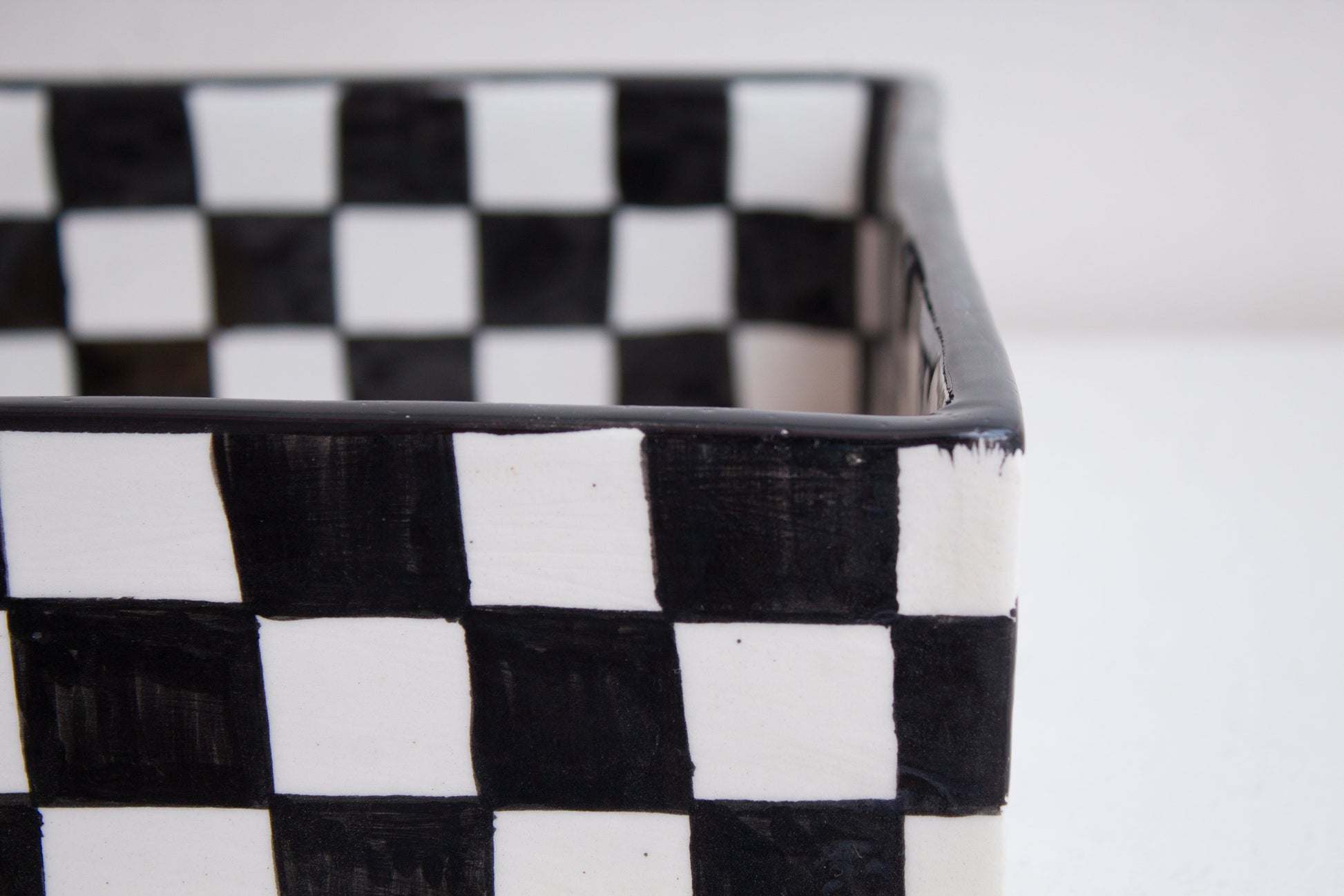Close-up detail of black and white checkered pattern on rectangular basin rim and exterior