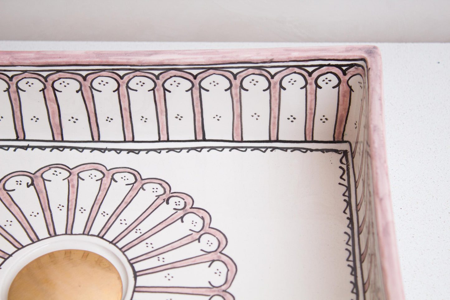 Interior detail view showing central sunburst medallion surrounded by arch patterns with centered drain of handcrafted rectangular ceramic vessel sink