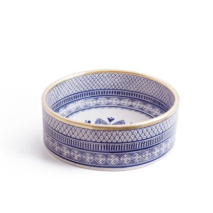 Three-quarter perspective view of handcrafted round ceramic basin featuring blue and white geometric patterns