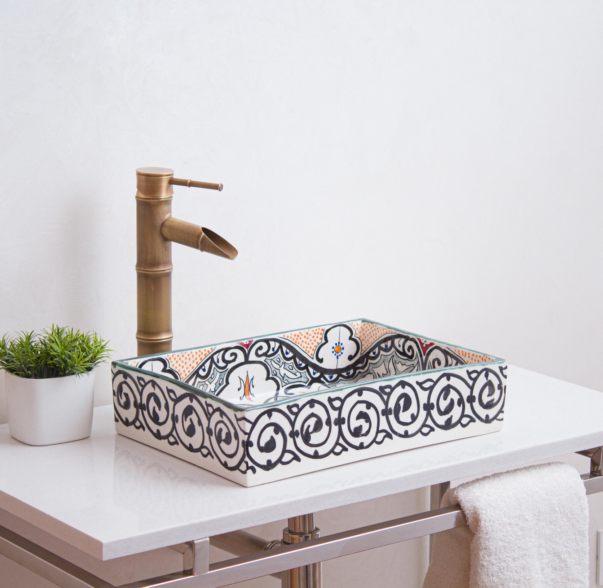 Handcrafted Moroccan ceramic rectangular sink with blue dotted floral motifs and scrollwork border displayed on white vanity with bamboo faucet