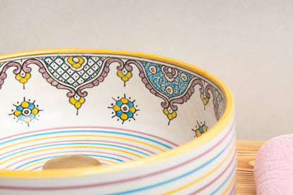 Moroccan ceramic sink rim detail displaying hand-painted geometric patterns and decorative motifs