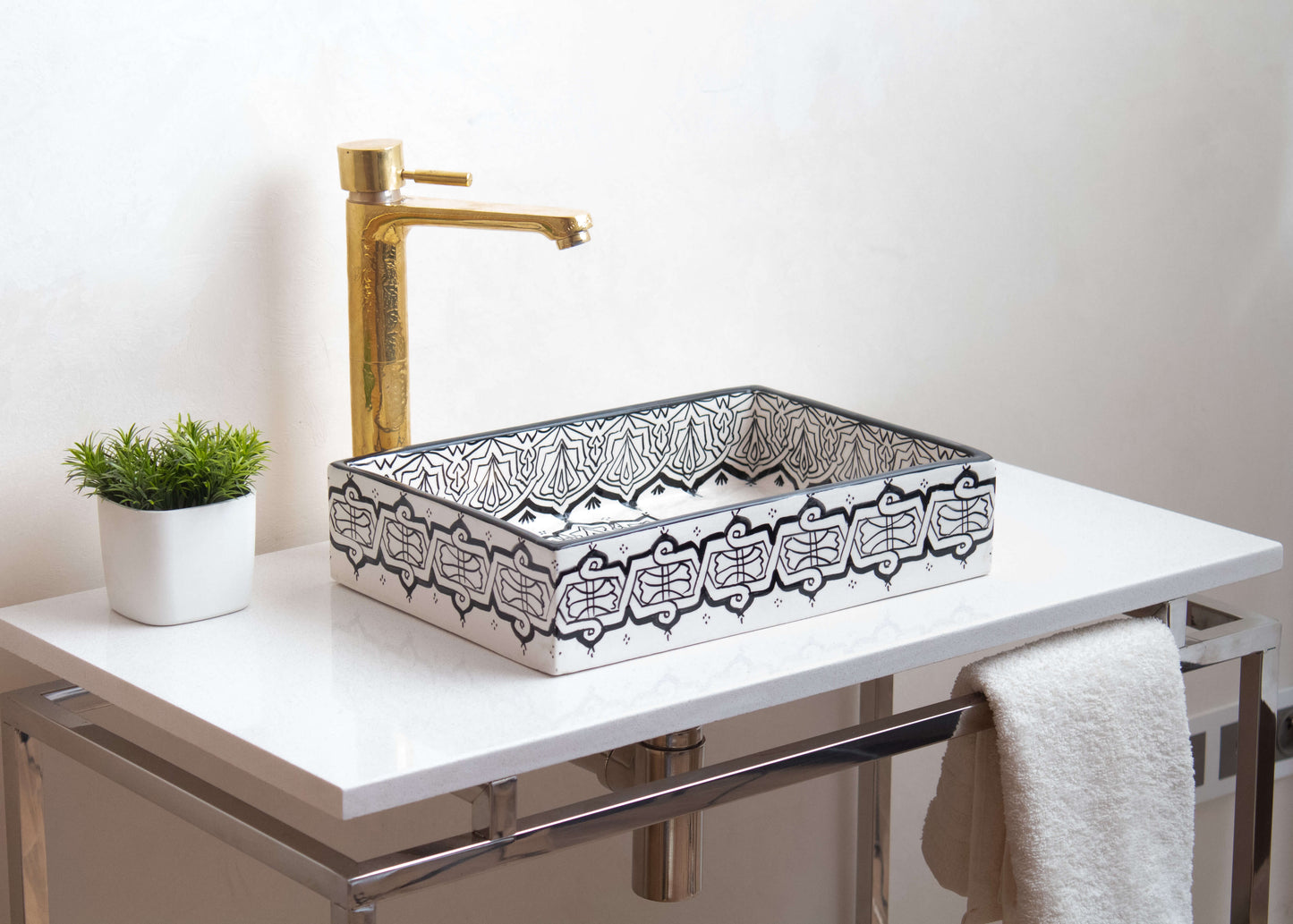 Installed Moroccan ceramic vessel sink on white countertop with gold faucet and small plant, showcasing elegant bathroom application and proper placement