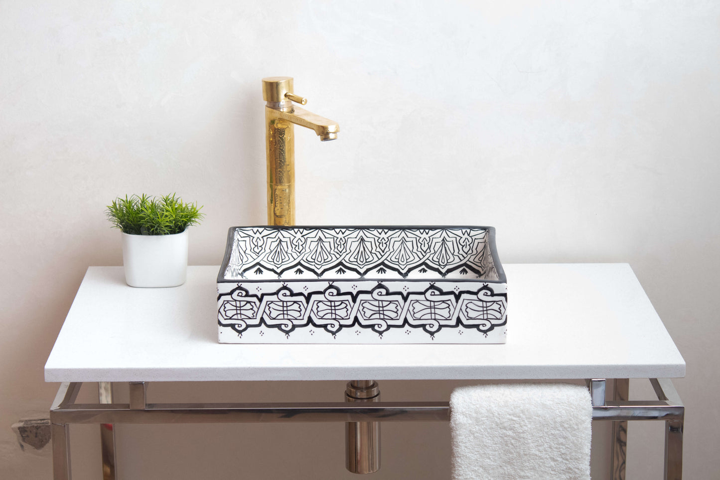 Alternate angle of installed Moroccan ceramic vessel sink in bathroom setting with brass faucet, white countertop and decorative plant, showing functional use
