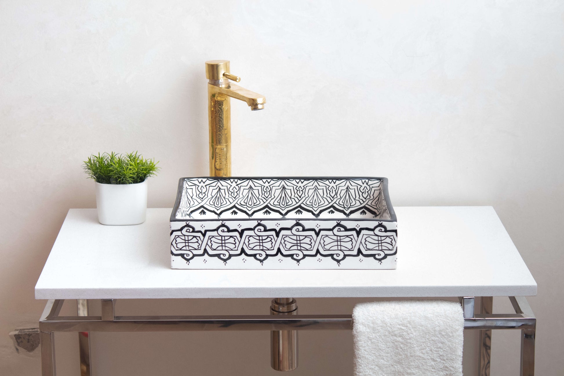 Alternate angle of installed Moroccan ceramic vessel sink in bathroom setting with brass faucet, white countertop and decorative plant, showing functional use