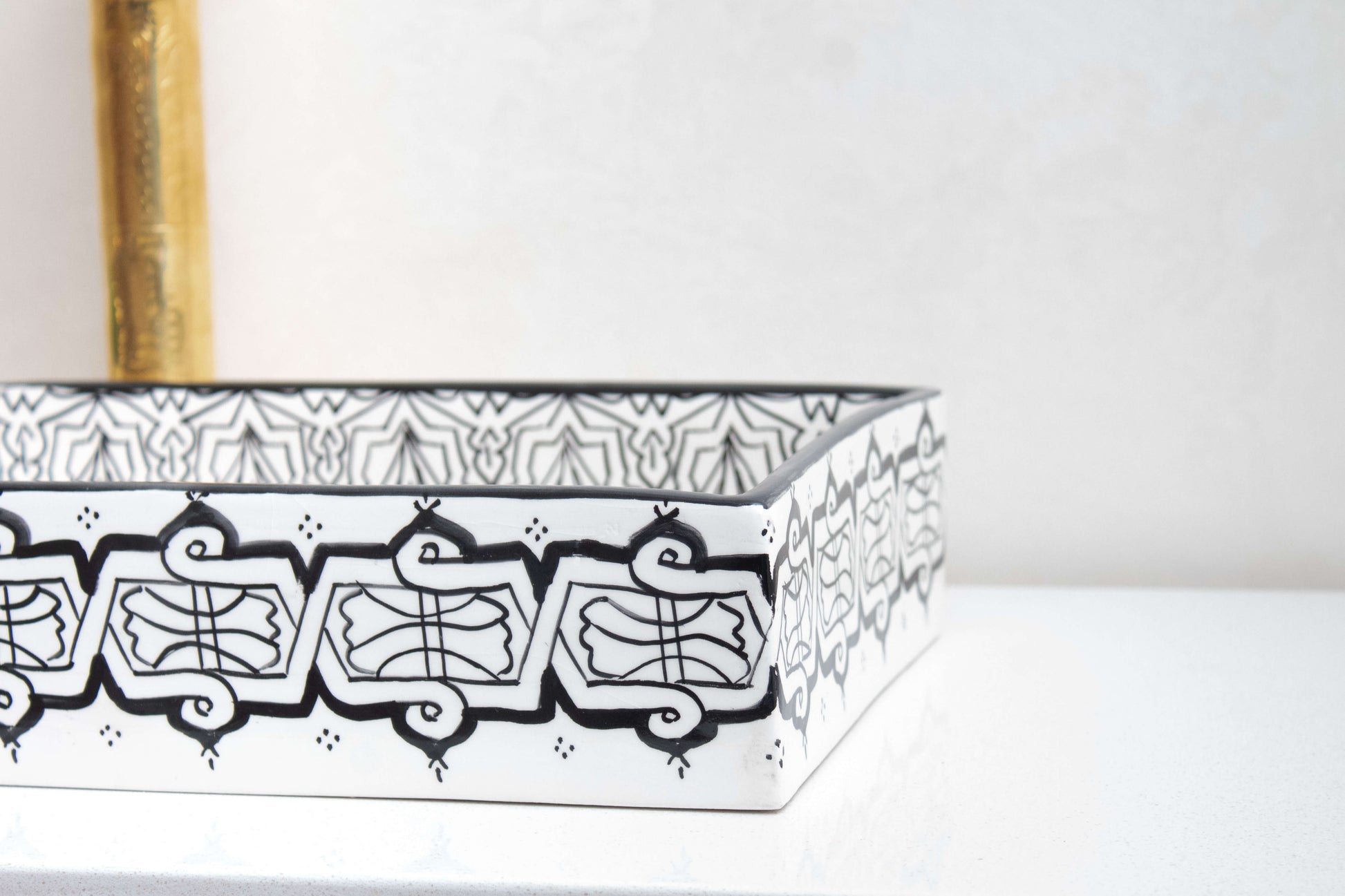 Interior corner detail of Moroccan ceramic vessel sink showcasing the mandala pattern with gold center medallion and precise black geometric designs on white background
