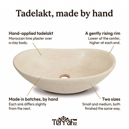 Infographic of the beige oval tadelakt vessel sink: hand-applied Moroccan lime plaster over clay, a gently rising rim, made by hand in batches, in two sizes