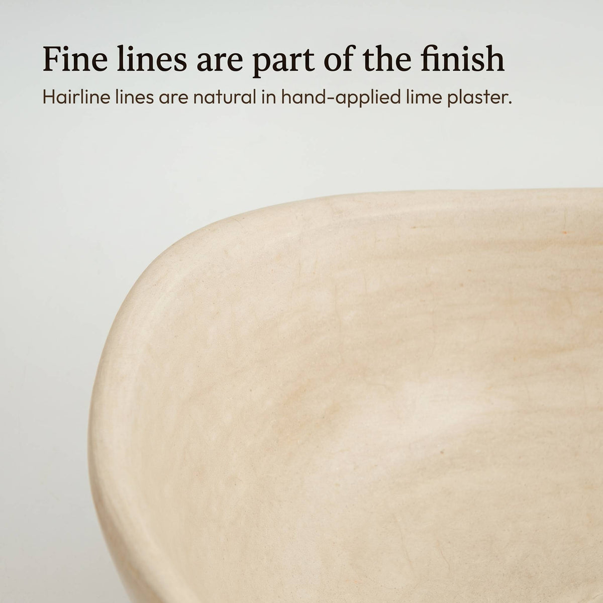 Close-up of the beige tadelakt sink's rim and basin, showing the fine hairline lines that form naturally in hand-applied lime plaster