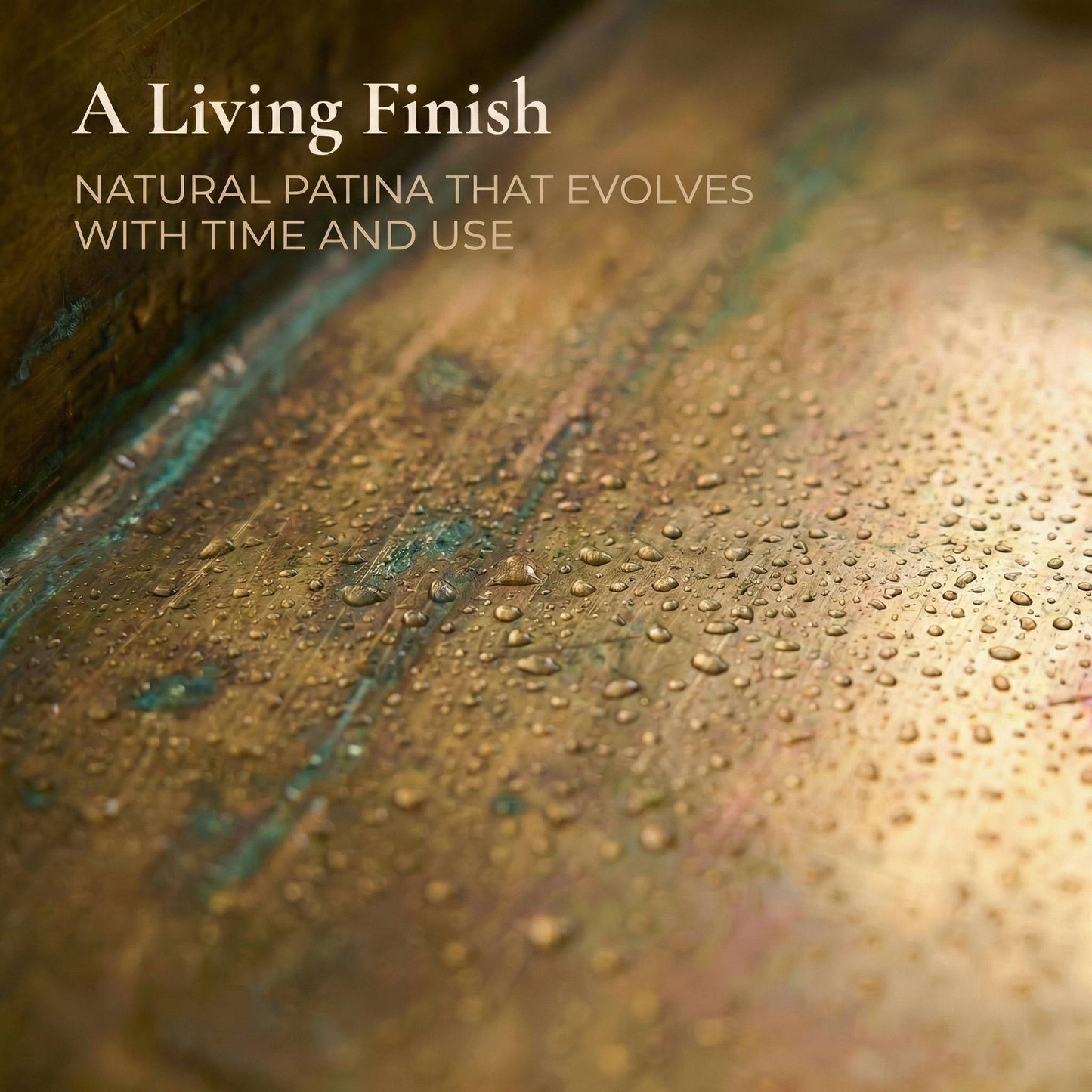 Macro close-up of water droplets on the surface of an aged brass kitchen sink, showing the evolving living patina with natural verdigris green and warm bronze tones that develop over time with use.