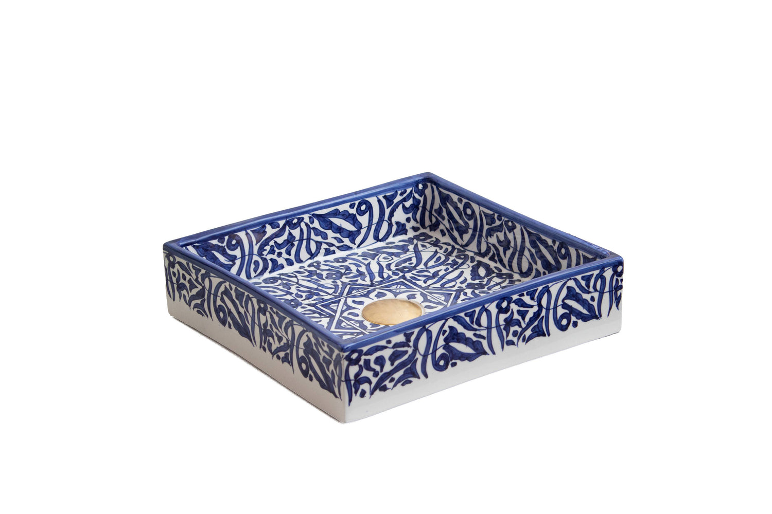 Three-quarter view of handmade ceramic bathroom sink with navy blue Islamic-inspired pattern