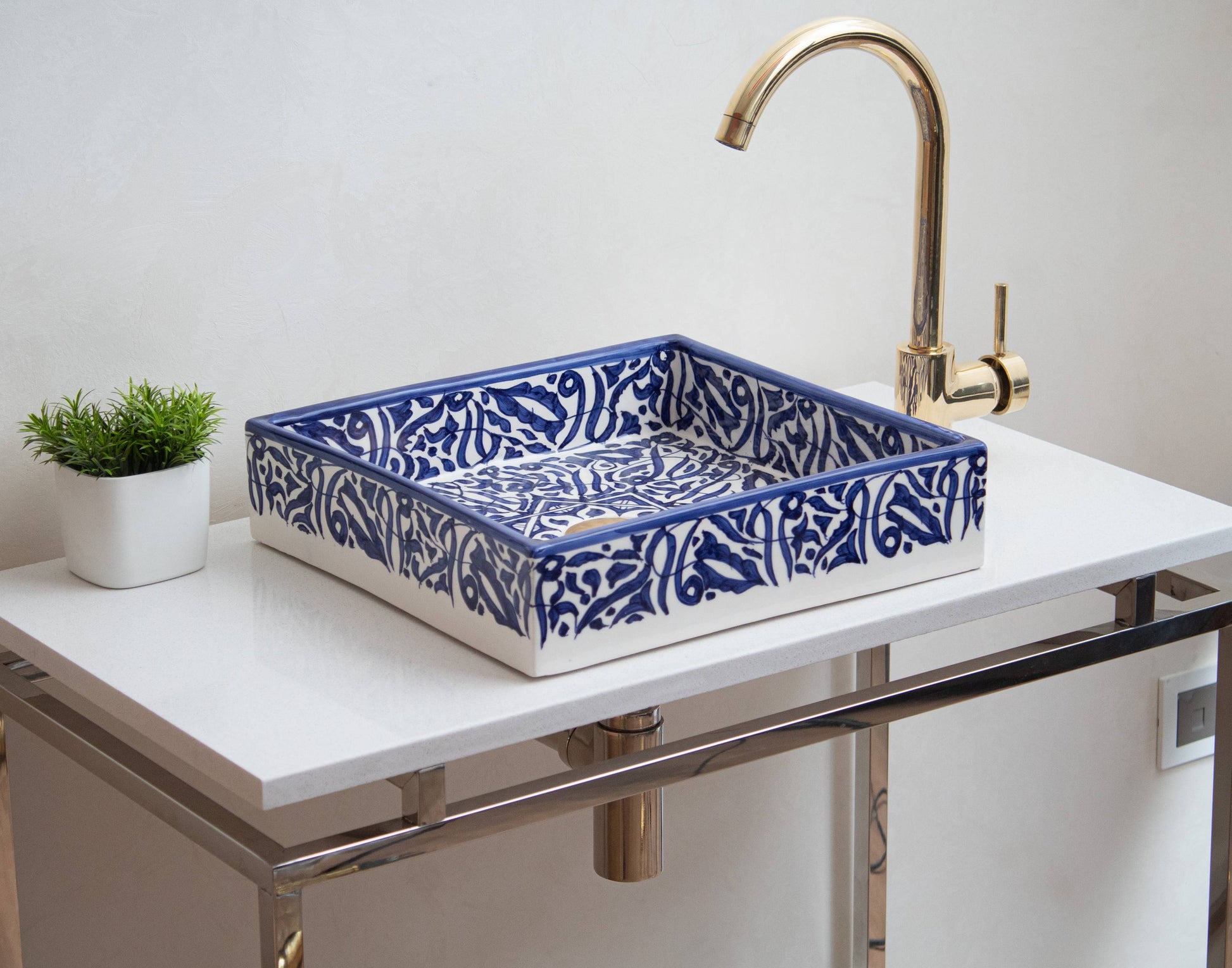 Handmade rectangular ceramic sink with blue Moroccan geometric pattern on white vanity with gold faucet