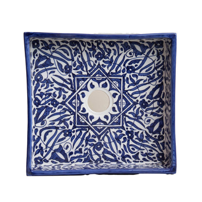 Overhead view of rectangular vessel sink showing navy blue geometric tile pattern and cream interior