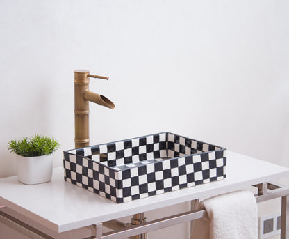 Black and white checkerboard ceramic basin styled with brass bamboo faucet on modern vanity
