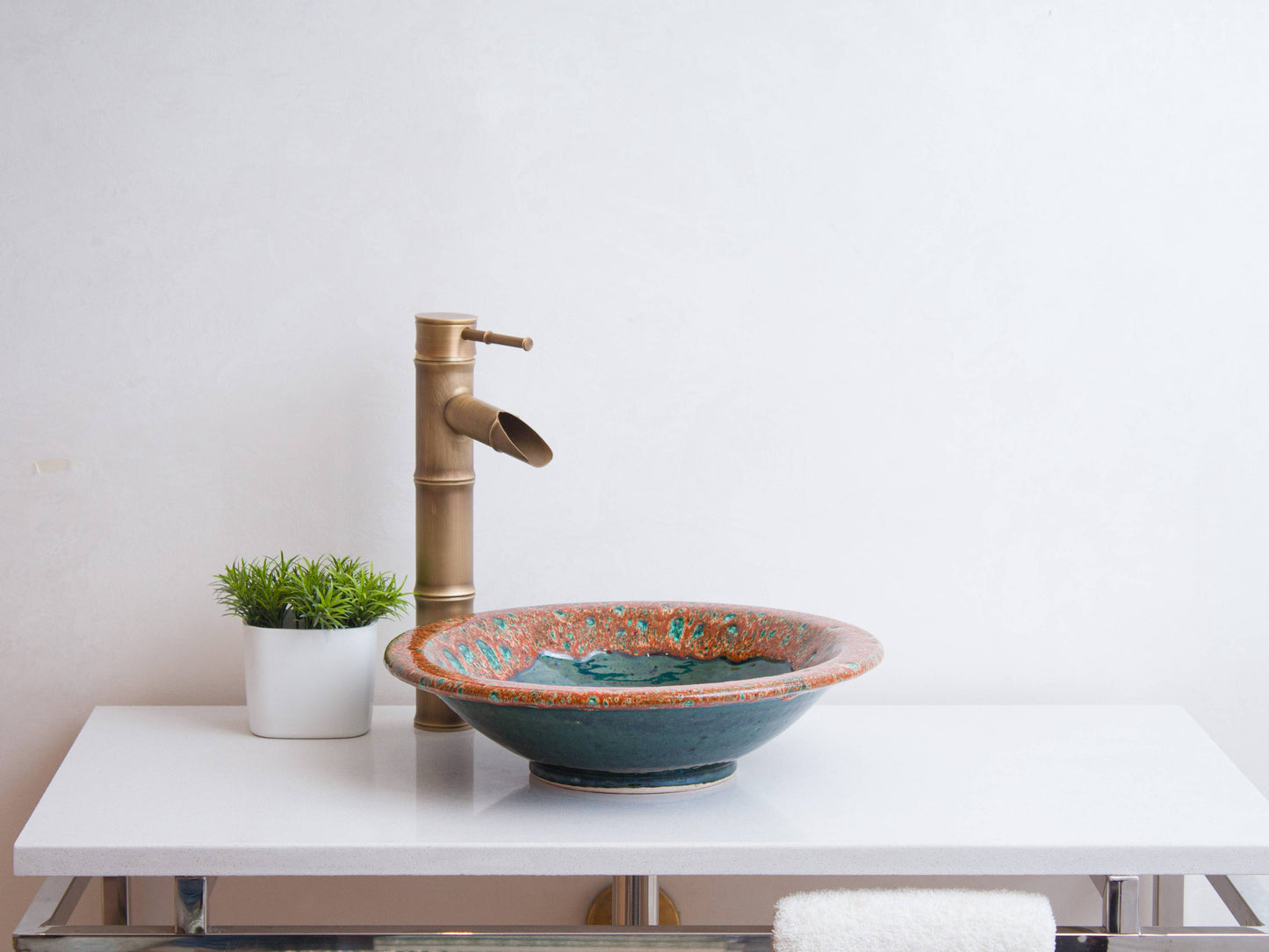 Side view of round vessel sink on white vanity showing footed base and decorative rim