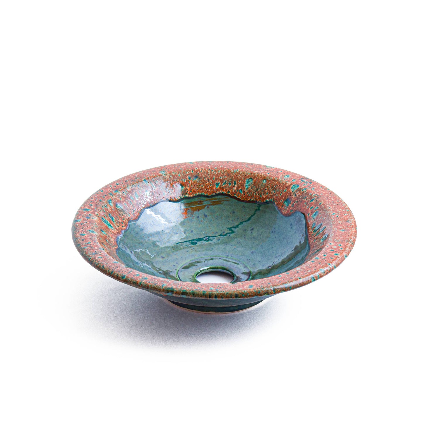 Overhead view of round vessel sink showing coral speckled rim and teal interior