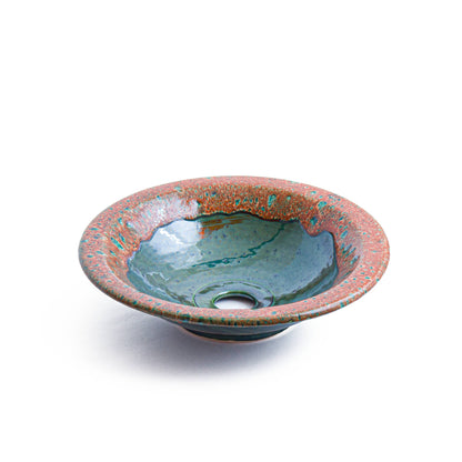 Overhead view of round vessel sink showing coral speckled rim and teal interior