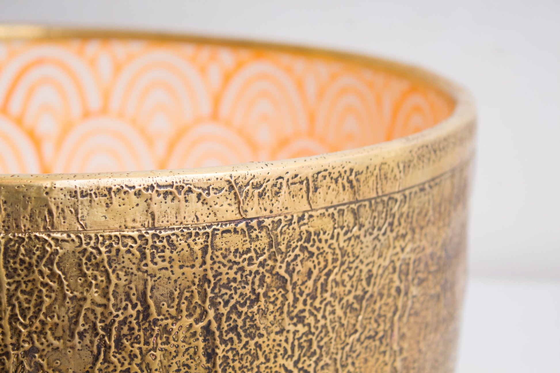 Macro detail view of handcrafted ceramic basin rim showcasing crackled brass textured exterior finish and craftsmanship