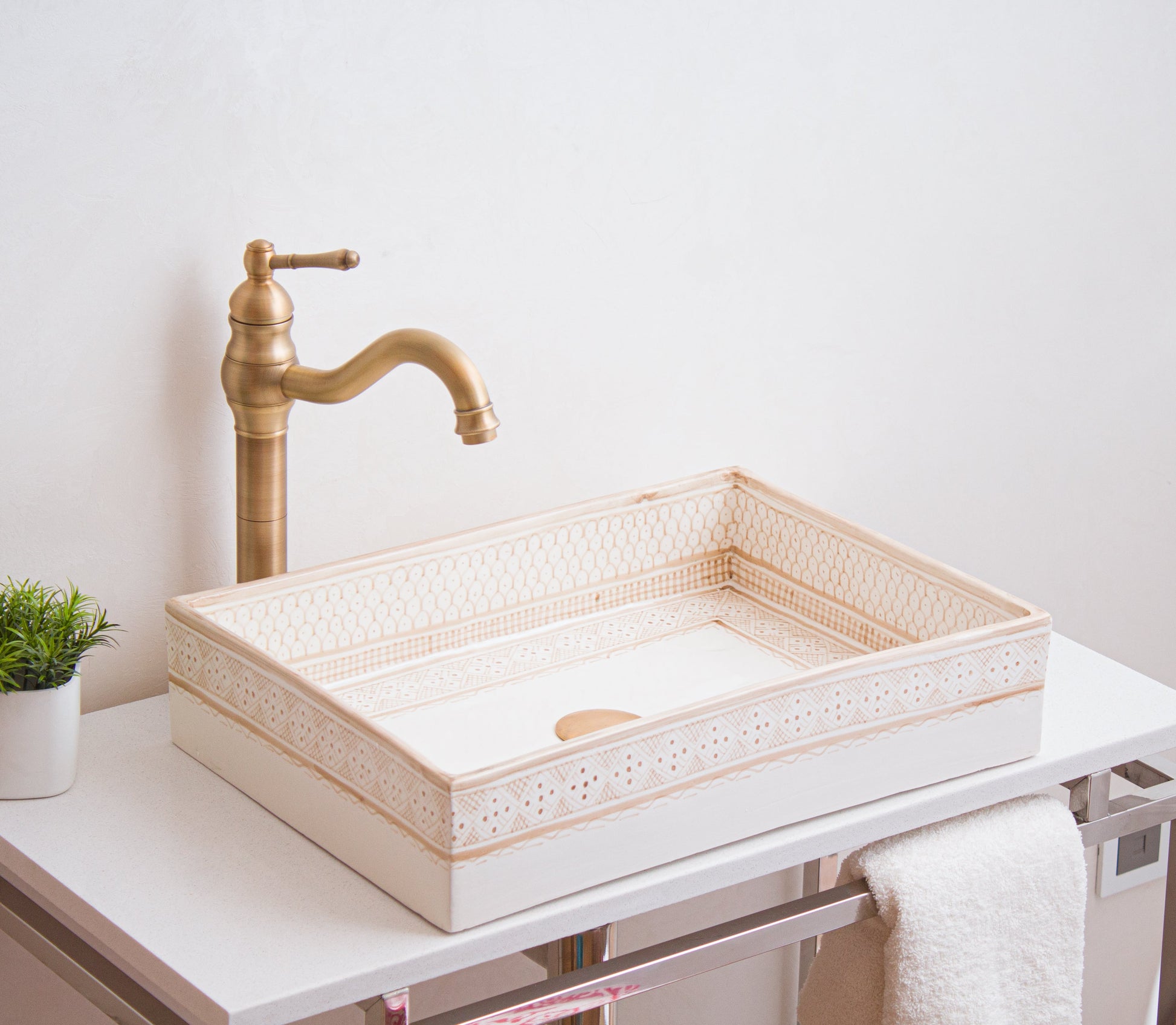 Handcrafted rectangular sink photographed from side angle showcasing detailed beige border patterns